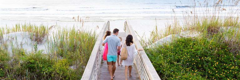 escape vacation package family walking to beach